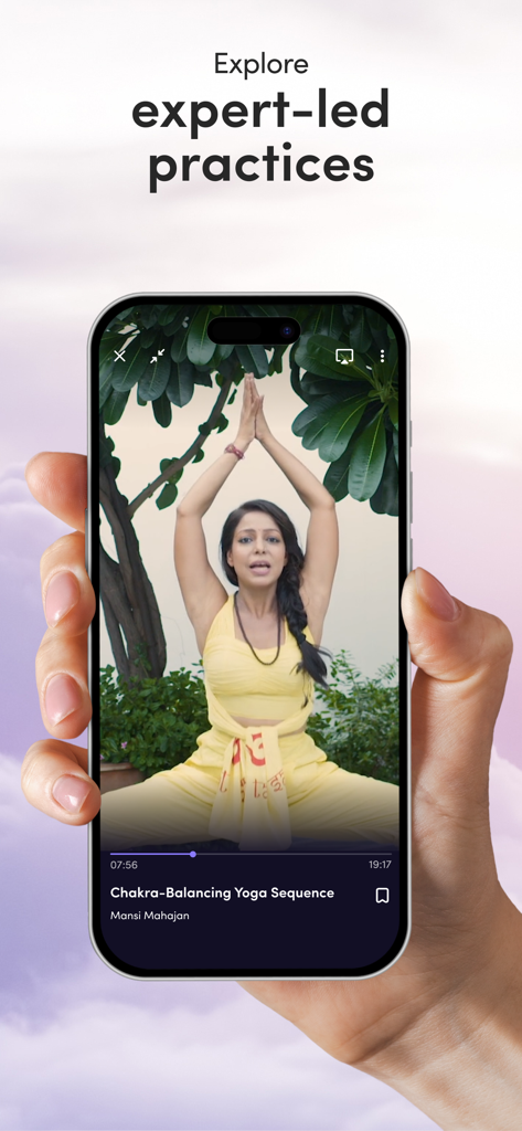 Roundglass Living: Wellbeing - A hand holding a smartphone displaying an expert-led yoga sequence on the Roundglass Living wellbeing app