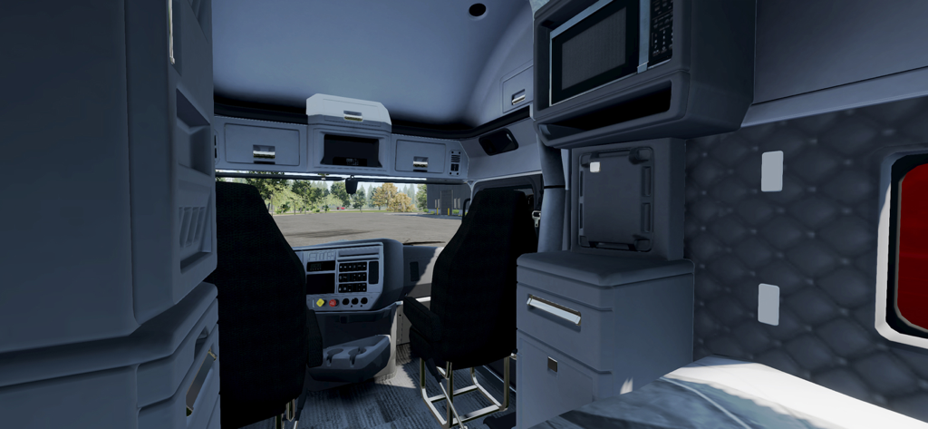 Detailed interior view of a truck cabin with a microwave and sleeping area