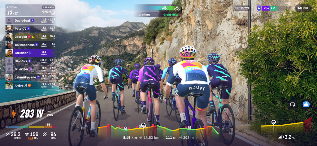 A group of virtual cyclists riding on a scenic coastal road in the ROUVY indoor cycling app
