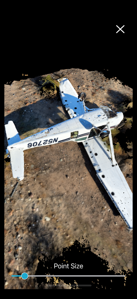 Recon-3D - A professional 3D point cloud scan of a crashed light aircraft on dirt ground within the Recon-3D mobile application.
