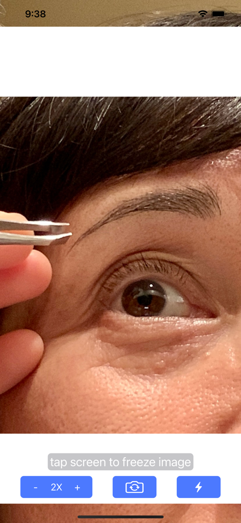Magnifying Glass & Mirror - Close up of an eye and eyebrow being groomed with tweezers using the magnifying mirror app zoom interface