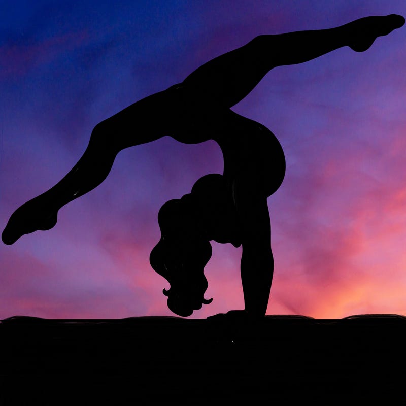 gymnast doing split handstand on a beam