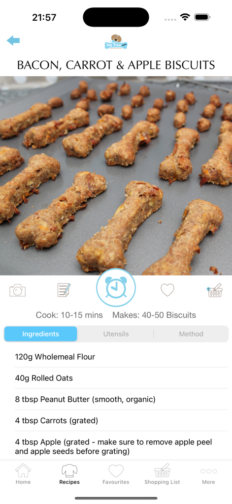 Homemade bone-shaped bacon carrot and apple dog biscuits on a baking sheet with recipe details