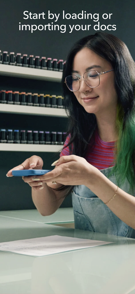 TurboTax: File Your Tax Return - Uma mulher usando o seu smartphone para digitalizar um documento fiscal na aplicação móvel TurboTax.