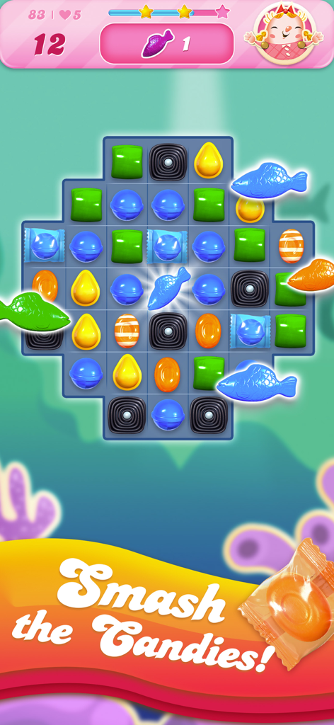 Candy Crush Saga match-3 puzzle board featuring colorful candies and blue fish boosters with a smash the candies caption.