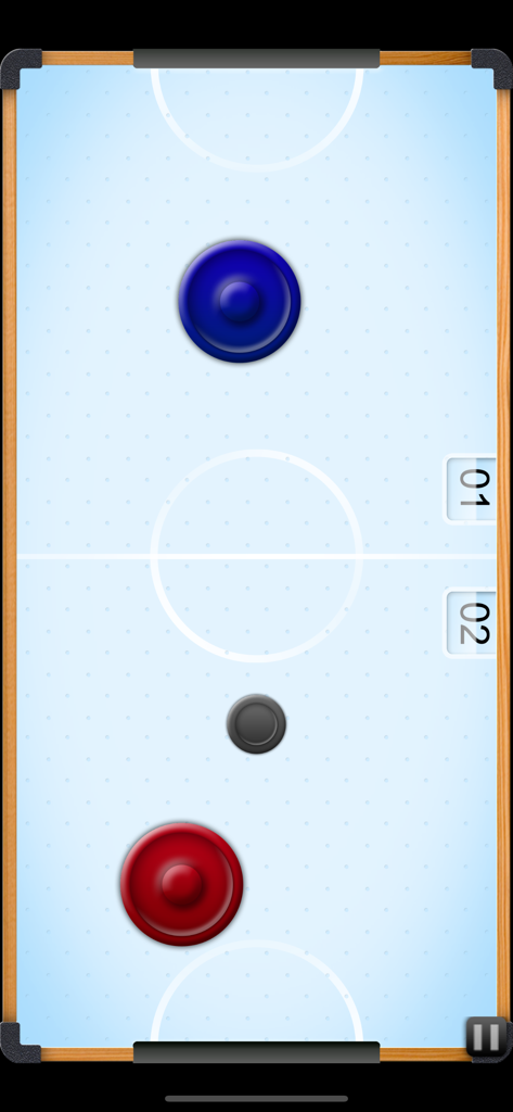Top down view of an air hockey table with blue and red mallets and a black puck