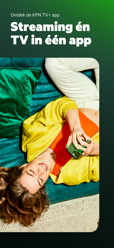 KPN TV+ App - A woman lying on a couch using the KPN TV plus app on her smartphone