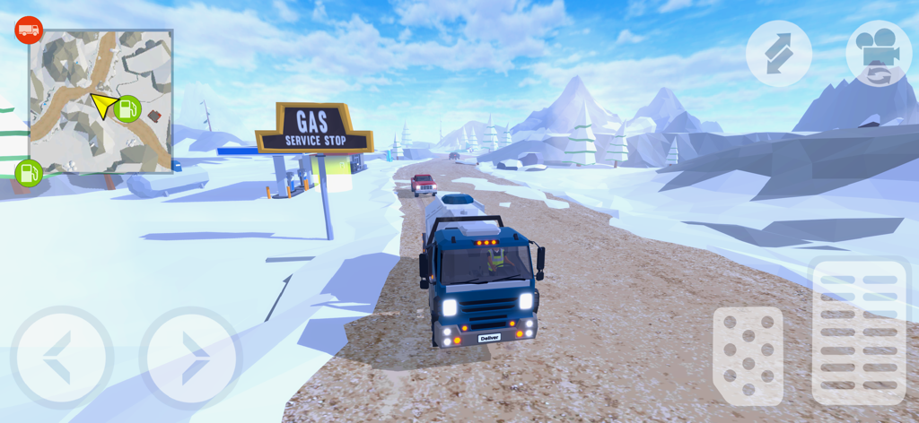 Un camión azul conduciendo por una carretera de montaña, pasando por una gasolinera en un paisaje nevado