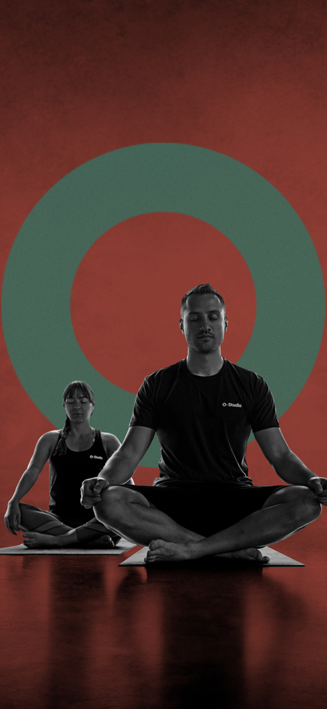 O-Studio - Um homem e uma mulher praticando meditação mindfulness em um estúdio de yoga.