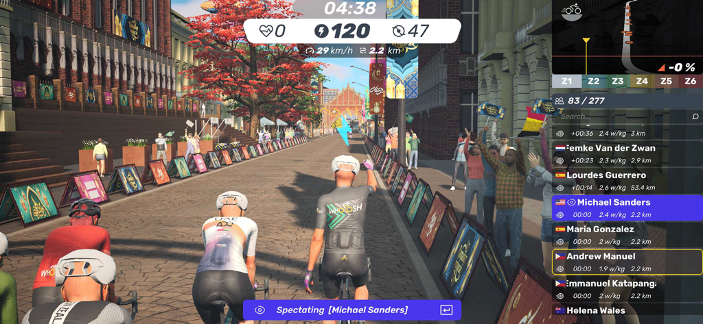 A screenshot of the MyWhoosh indoor cycling app showing a virtual race through a city with avatars on bikes and a live performance dashboard.