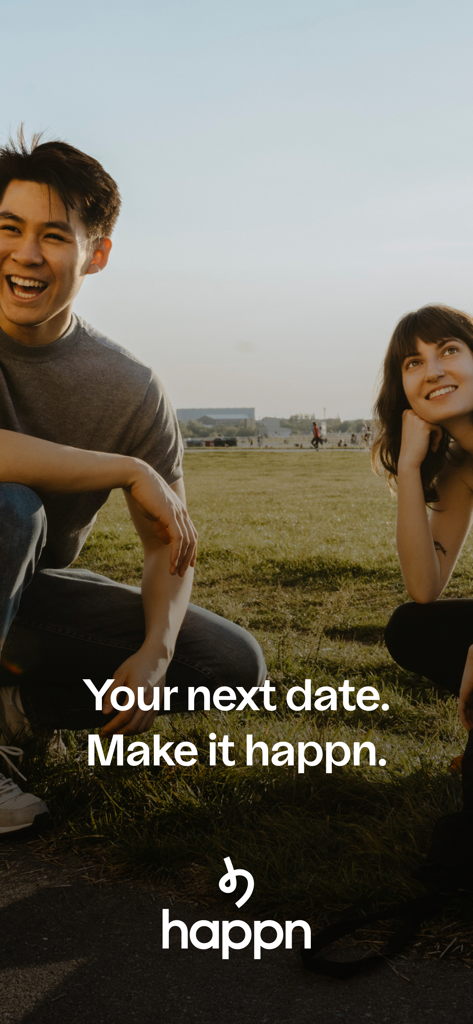 A happy young man and woman sitting together in an urban park with the happn app slogan Your next date Make it happn