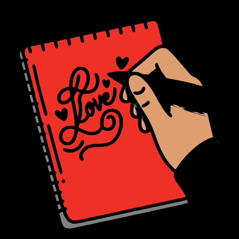 a hand writing “love” in calligraphy on a notebook