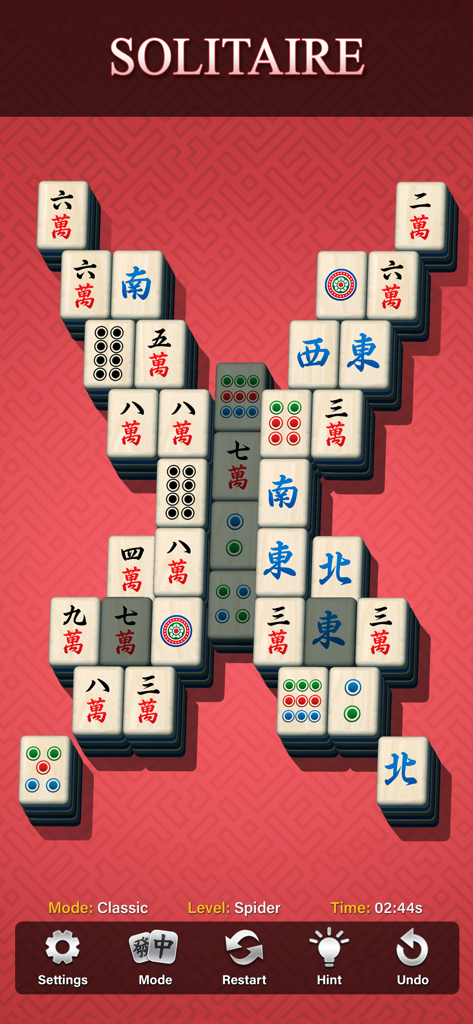 Jugabilidad del juego de emparejar Mahjong que muestra un diseño en forma de araña de fichas clásicas sobre un fondo de patrón rojo.