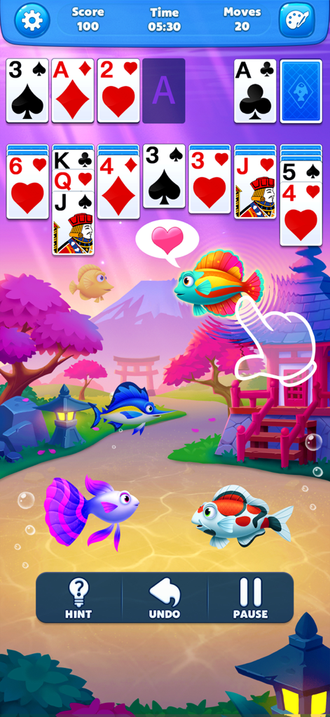 Solitaire game interface with cards over a vibrant Japanese-themed aquarium background featuring colorful fish and cherry blossoms.