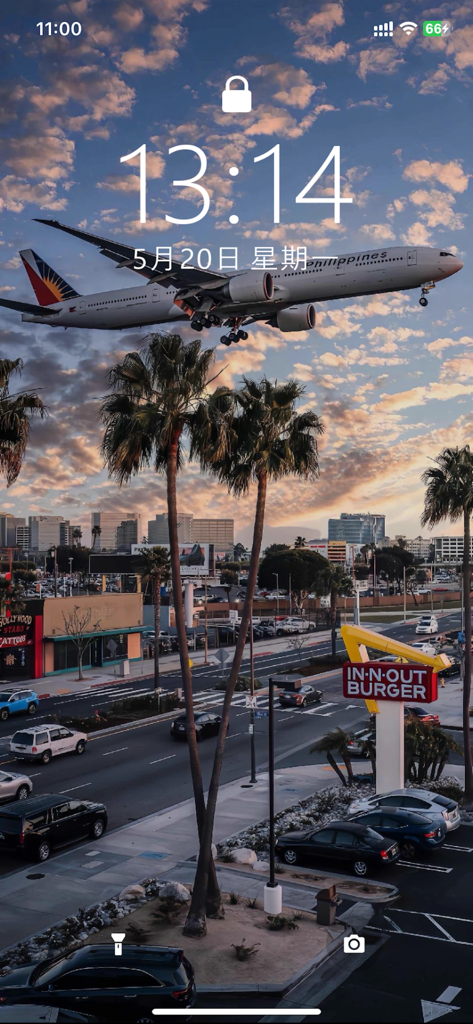 iPhone lock screen with a high resolution live wallpaper of an airplane landing over an urban city street