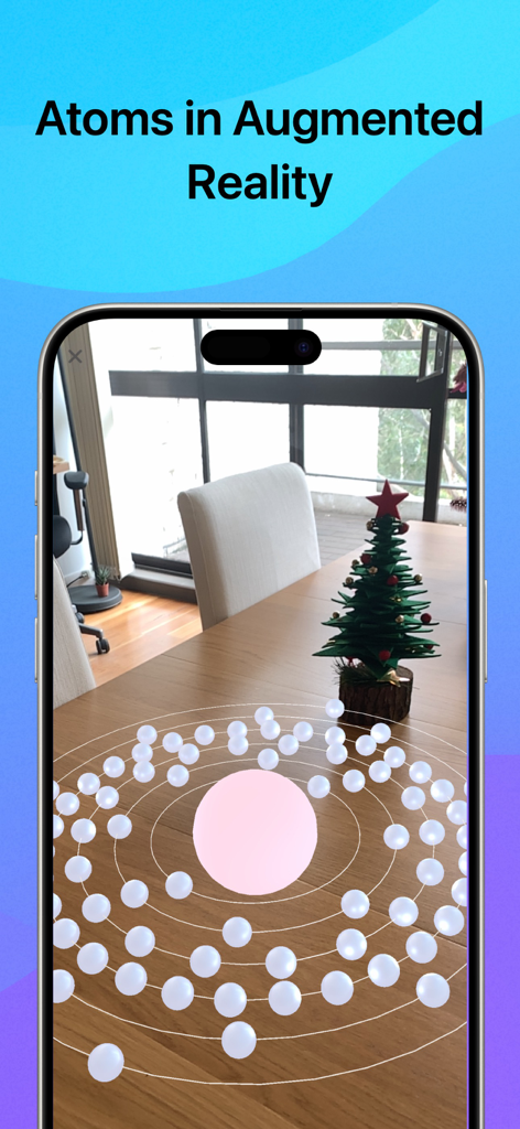 A smartphone displaying a 3D model of an atom in augmented reality on a wooden table