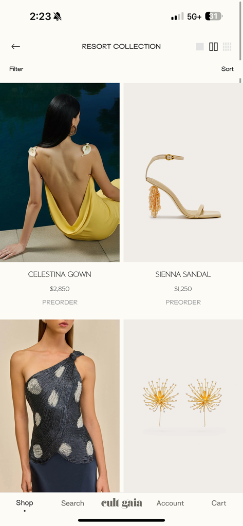 CULT GAIA - Pantalla móvil que muestra la Colección Resort de Cult Gaia con artículos de lujo como el vestido Celestina y las sandalias Sienna disponibles en preventa.