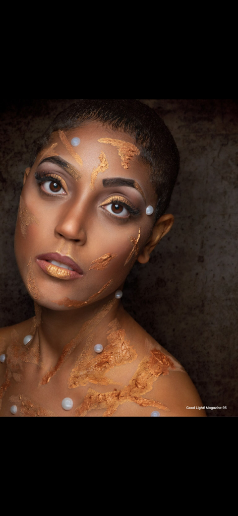 Ritratto di bellezza artistico con pittura dorata per il viso e perle