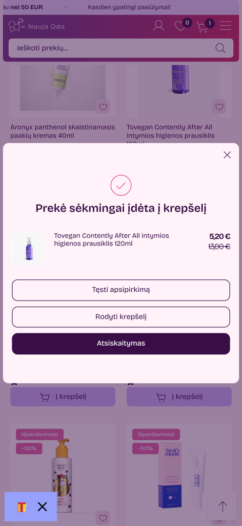 NaujaOda.lt - A confirmation popup in the NaujaOda mobile app showing a skincare product successfully added to the shopping cart with checkout options