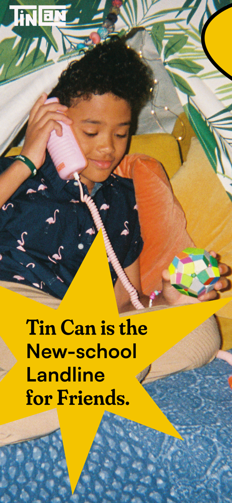 Tin Can - Companion App - A young child talking on a pink retro-style handset phone inside a blanket fort.
