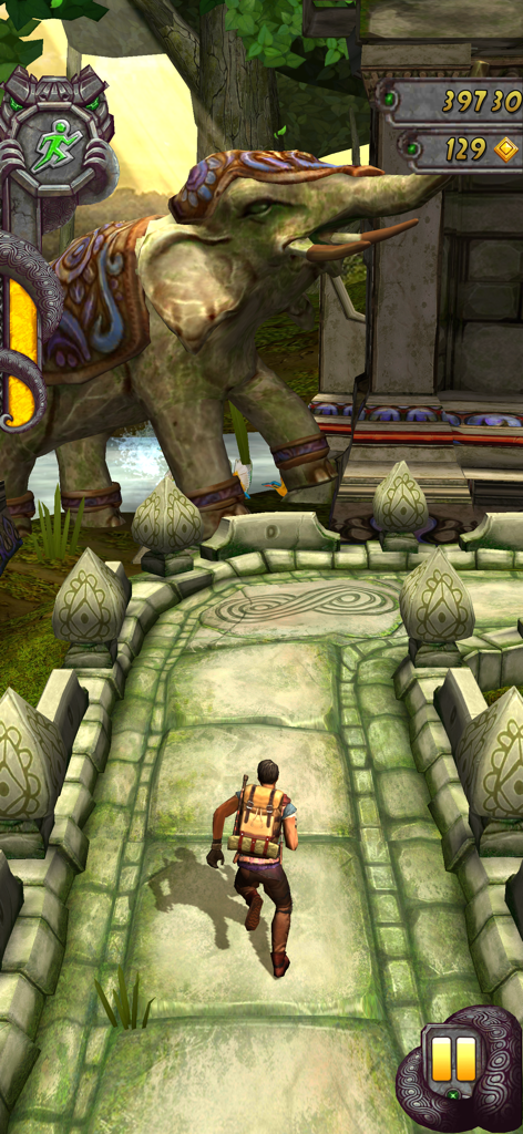 A character running through a jungle temple past a giant elephant statue in Temple Run 2