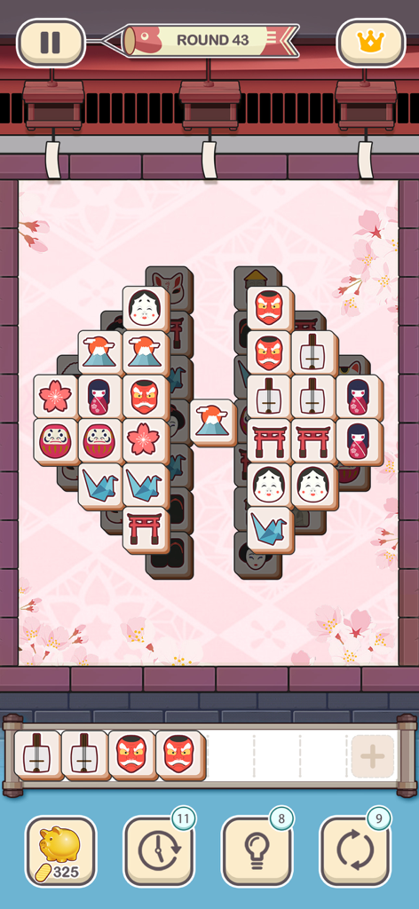 Jugabilidad de Tile Fun mostrando losetas temáticas japonesas como muñecas Daruma y flores de cerezo sobre un fondo rosa