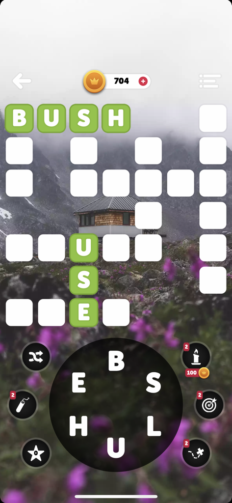 Words of the World! - A word puzzle game interface featuring a crossword grid and a letter wheel over a scenic nature background