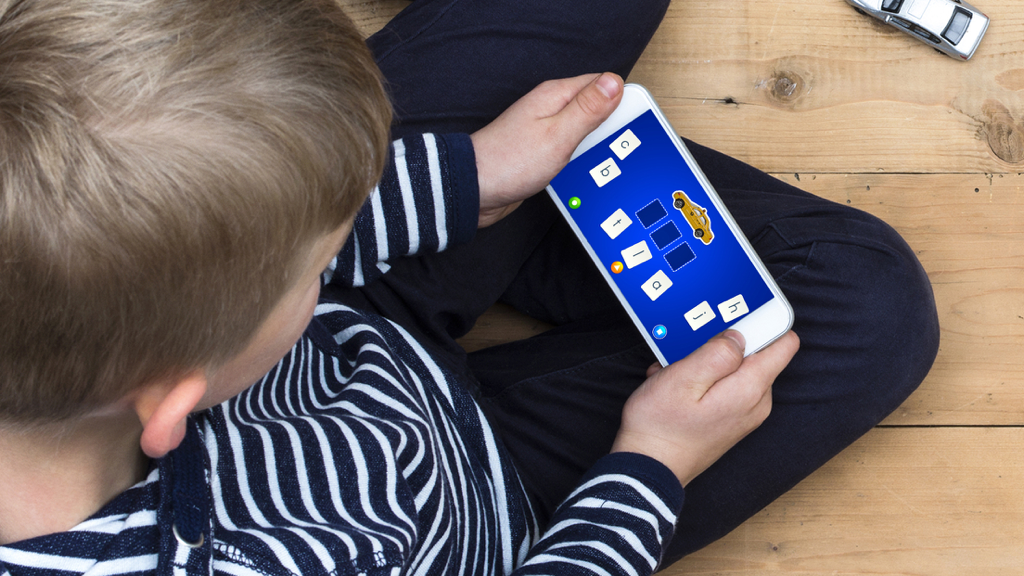 LetterSchool - Teach Spelling - Un niño pequeño usando la aplicación LetterSchool en un teléfono inteligente para practicar la ortografía de palabras