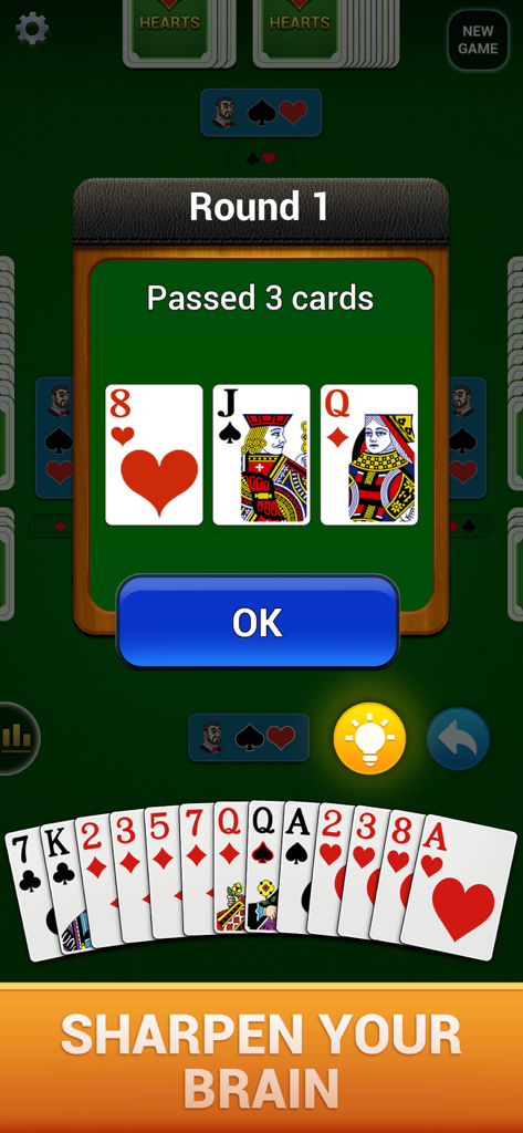 Hearts : Deluxe Card Game - A screenshot of Hearts Deluxe Card Game showing the card passing phase of Round 1 with large playing cards and the text Sharpen Your Brain.