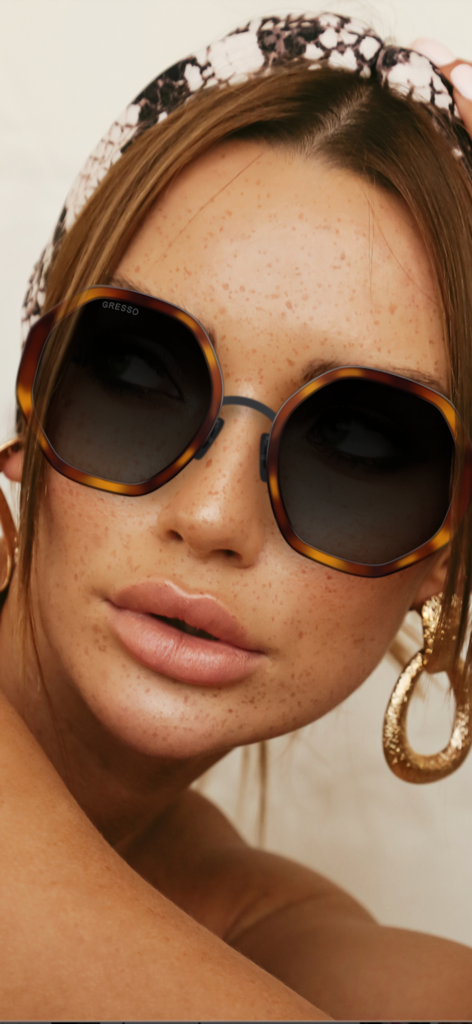 GRESSO | Titanium Eyewear - Woman modeling GRESSO titanium sunglasses with tortoiseshell frames