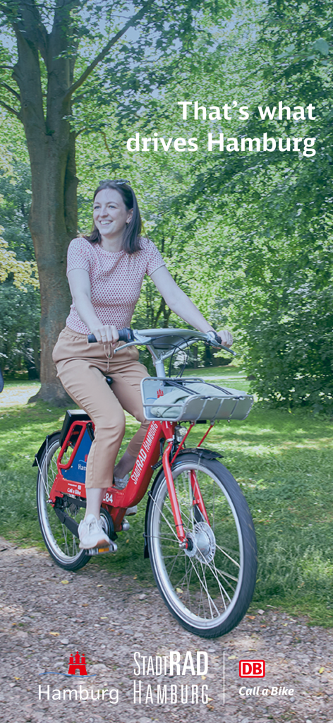 StadtRAD Hamburg - A woman riding a red StadtRAD Hamburg rental bike through a green park.