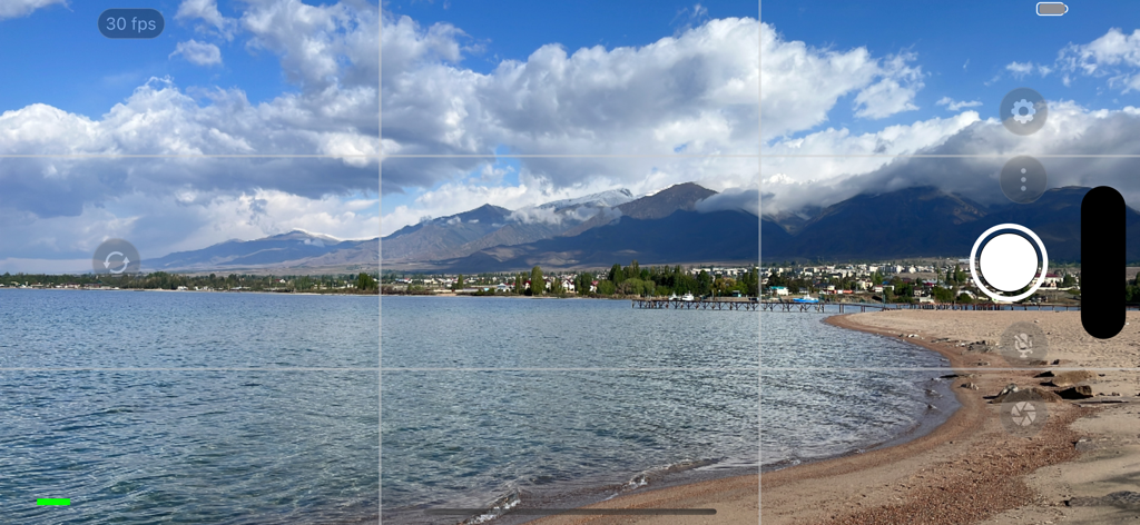 Larix Broadcaster: Live Stream - 山の風景を背景にした、プロフェッショナルなマニュアルコントロールとグリッド線が表示されたLarix Broadcasterのカメラインターフェース