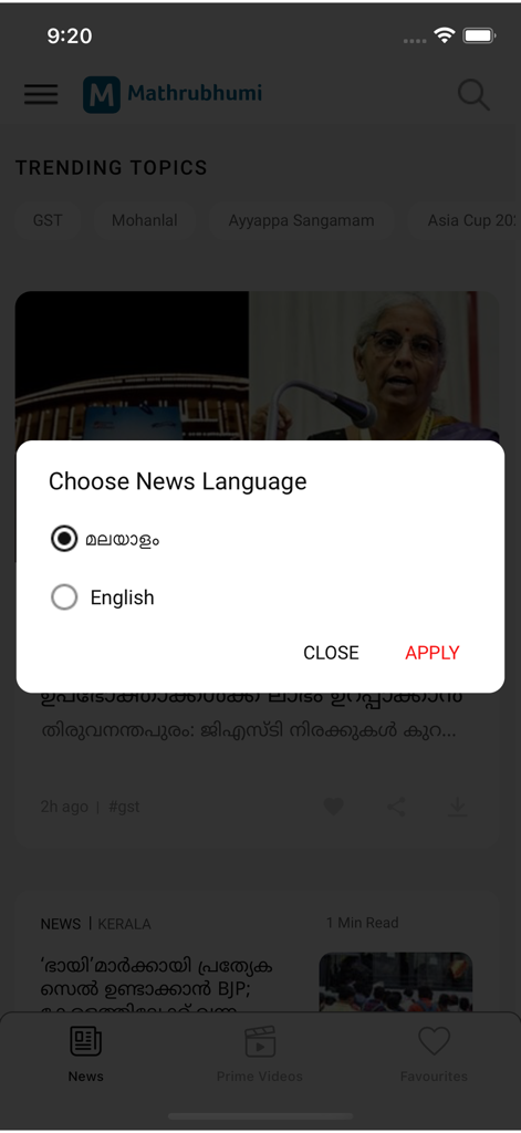 Mathrubhumi - Interfaz de la aplicación Mathrubhumi que muestra una ventana emergente de Elegir idioma de noticias con opciones en malayalam e inglés sobre un flujo de noticias