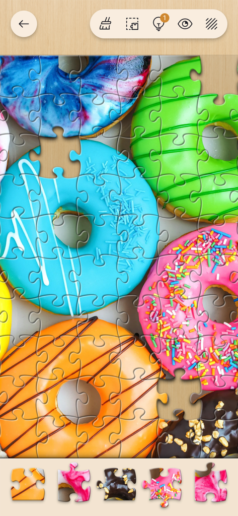 Jigsawscapes® - Jigsaw Puzzles - Schermata di gioco di Jigsawscapes che mostra un colorato puzzle di ciambelle in fase di risoluzione con pezzi in basso