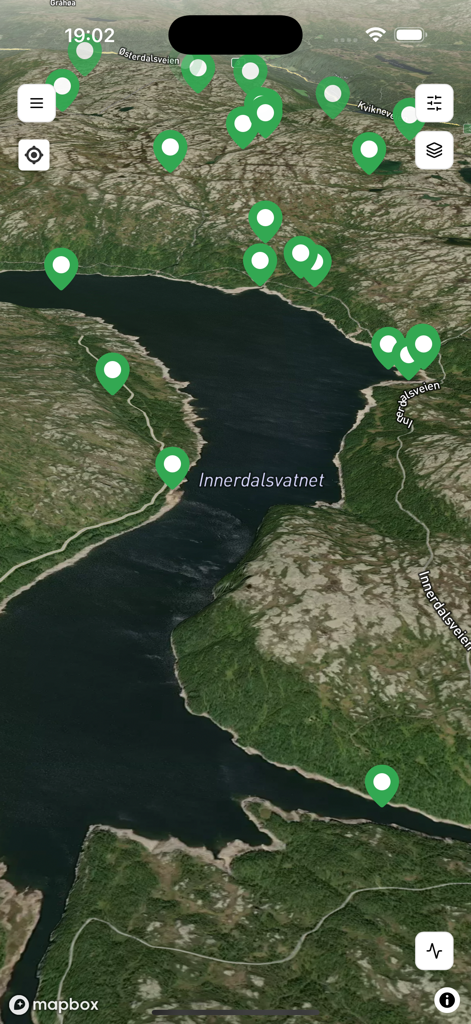 Satellite map view in Findmy app showing livestock locations with green pins in a rural mountain area