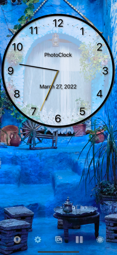 PhotoClock Pro - PhotoClock Pro app displaying a customizable analog clock over a blue scenic patio photo background