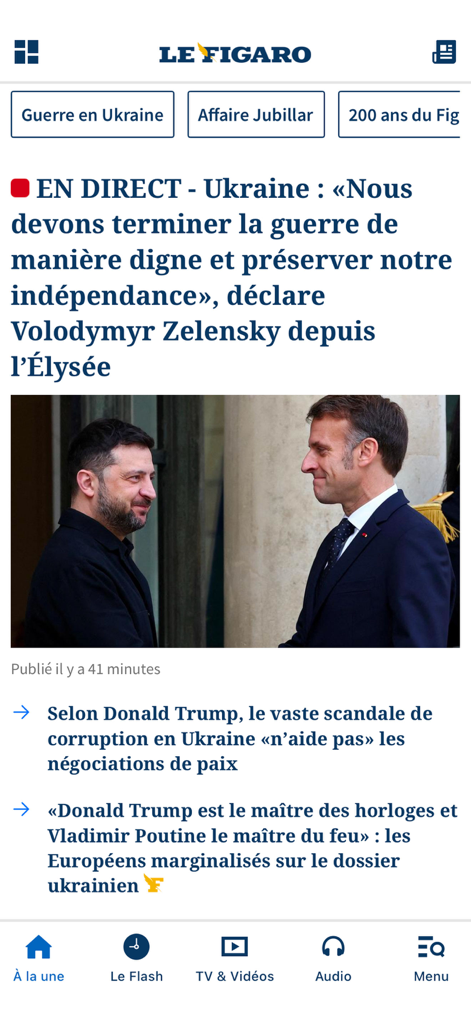 Interface do aplicativo Le Figaro exibindo uma manchete ao vivo sobre a Ucrânia com uma foto do presidente Zelensky e do presidente Macron.