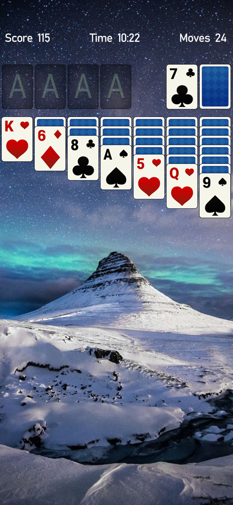 Solitaire Card Games for Brain - Interfaz de un juego de cartas clásico Klondike Solitario con un fondo de montañas nevadas y noche estrellada.