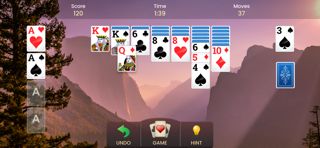 Solitaire card game gameplay with a scenic mountain sunset background in landscape mode