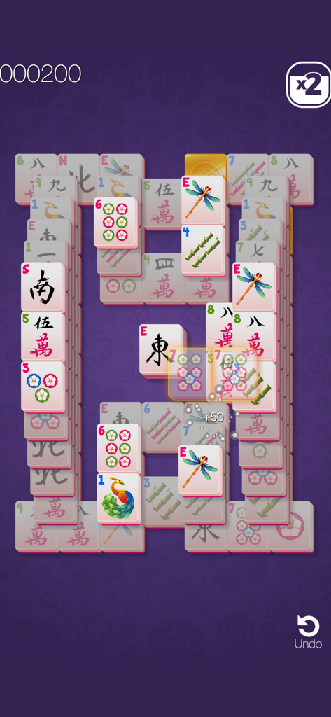 Tessere classiche di Mahjong Solitaire impilate su sfondo viola fantasia in Gold Mahjong FRVR.