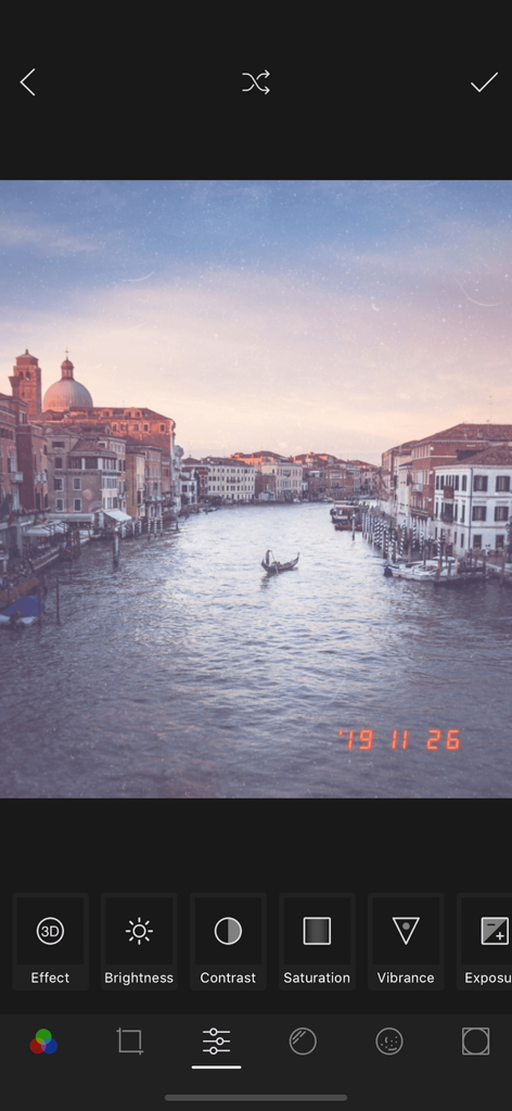 Une capture d'écran de l'interface de l'application 1998 Cam montrant une photo de style vintage d'un canal de Venise avec un tampon de date rétro et des outils d'édition manuels comme la luminosité et le contraste.