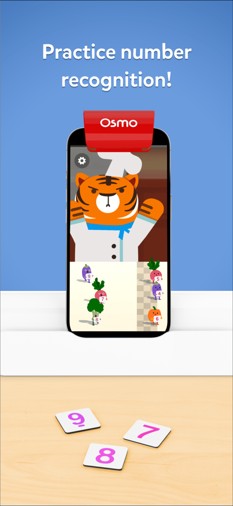 Osmo Numbers Toybox app on a smartphone showing a tiger character with physical number tiles for math learning.