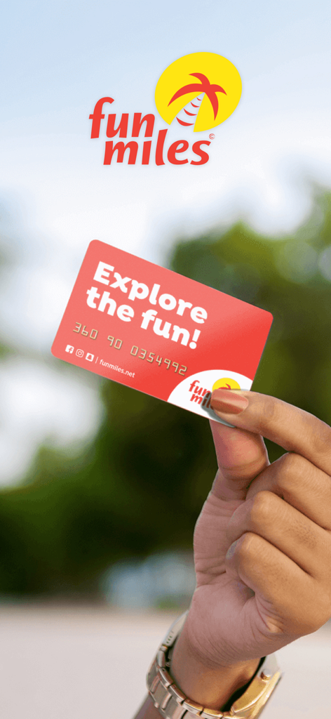 Fun Miles - Una mano sosteniendo una tarjeta de fidelidad Fun Miles roja con el texto Explore the fun sobre un fondo natural desenfocado.