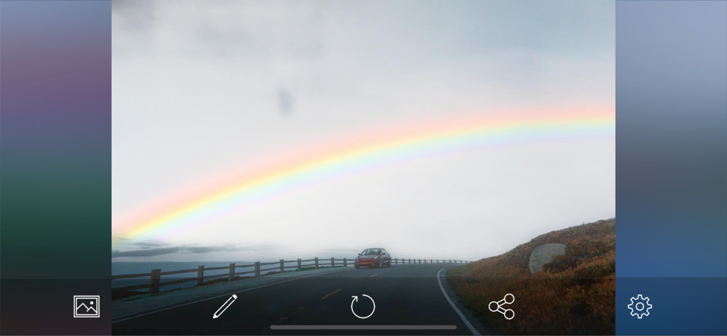 SkyAR - AI Change Photo Sky - A landscape photo of a car on a road with a vibrant rainbow sky being edited in the SkyAR app