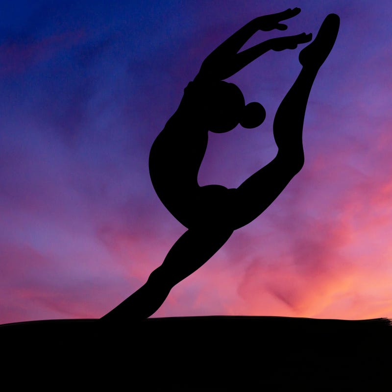 gymnast doing a leap in a leotard with a bent back leg