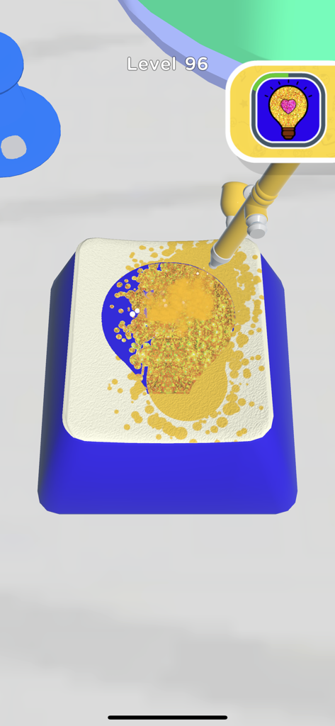 A player using gold glitter spray paint to create a lightbulb design on a computer keycap