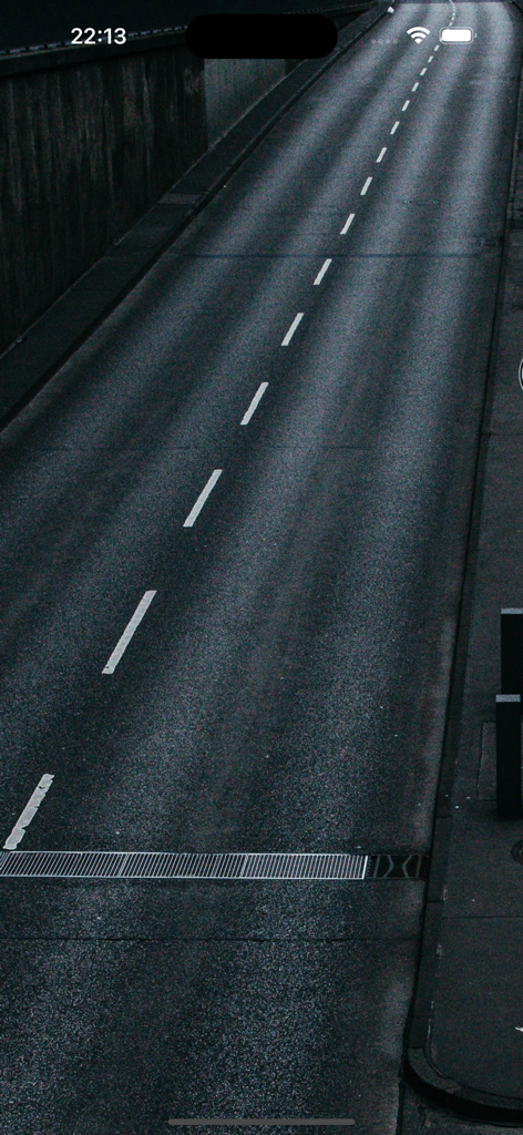 Vista de pájaro de una carretera de asfalto vacía con marcas blancas de carril