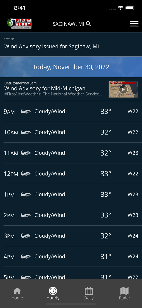 WNEM Weather - Hourly weather forecast for Saginaw Michigan on the WNEM Weather app showing a wind advisory and cloudy conditions.