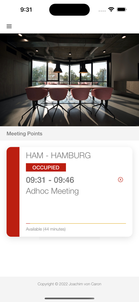 Meeting Point Digital Signage - iPhone interface showing a meeting room occupied status for an adhoc meeting in Hamburg