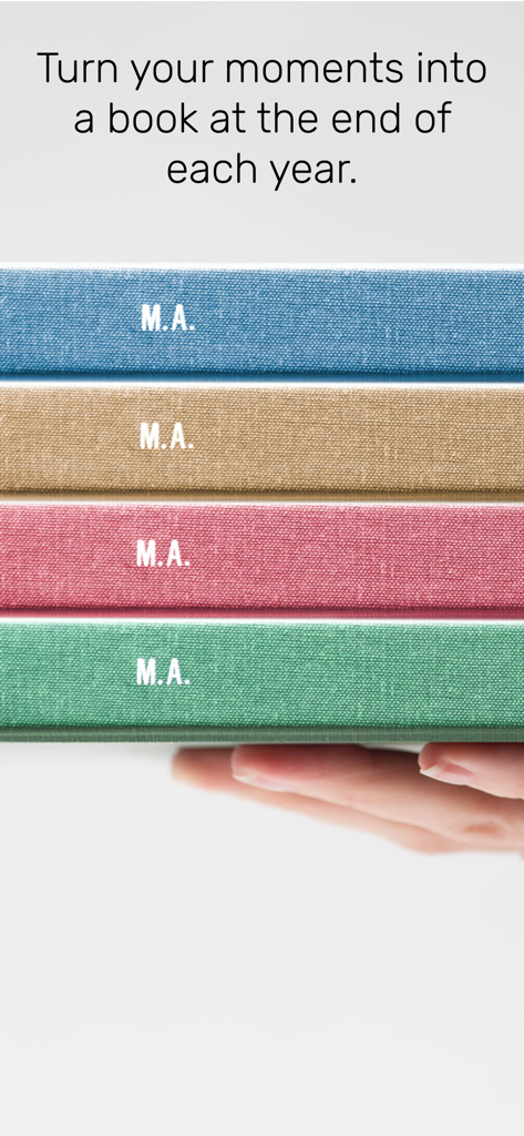 minutiae: Real Life - Ein Stapel von vier farbenfrohen, stoffgebundenen Büchern mit Initialen auf dem Buchrücken, die von einer Hand gehalten werden.